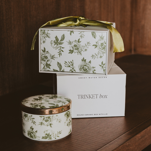 Decorative trinket box with floral design on a wooden surface